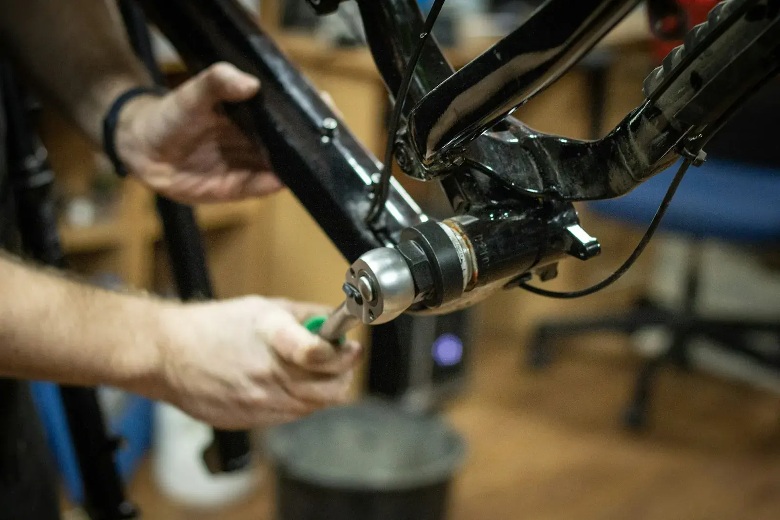 Handen van een fietsenmaker aan het crankstel van een fiets